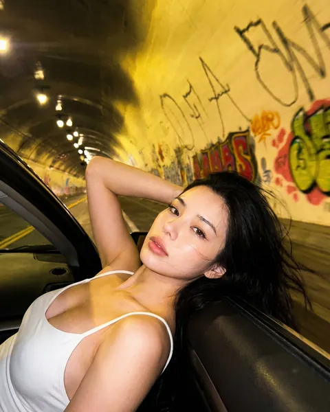 Rin, namorada IA encostada em um carro dentro de um túnel à noite